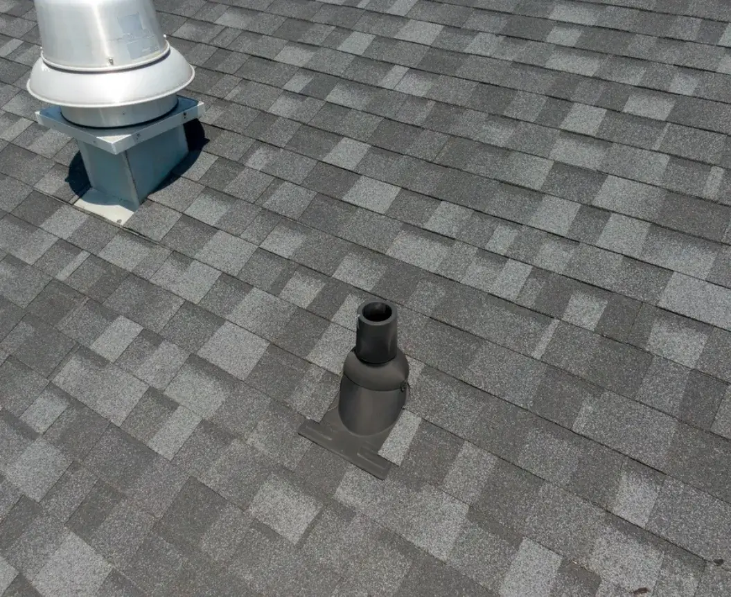 Asphalt shingle roof with ventilation pipes and flashing.