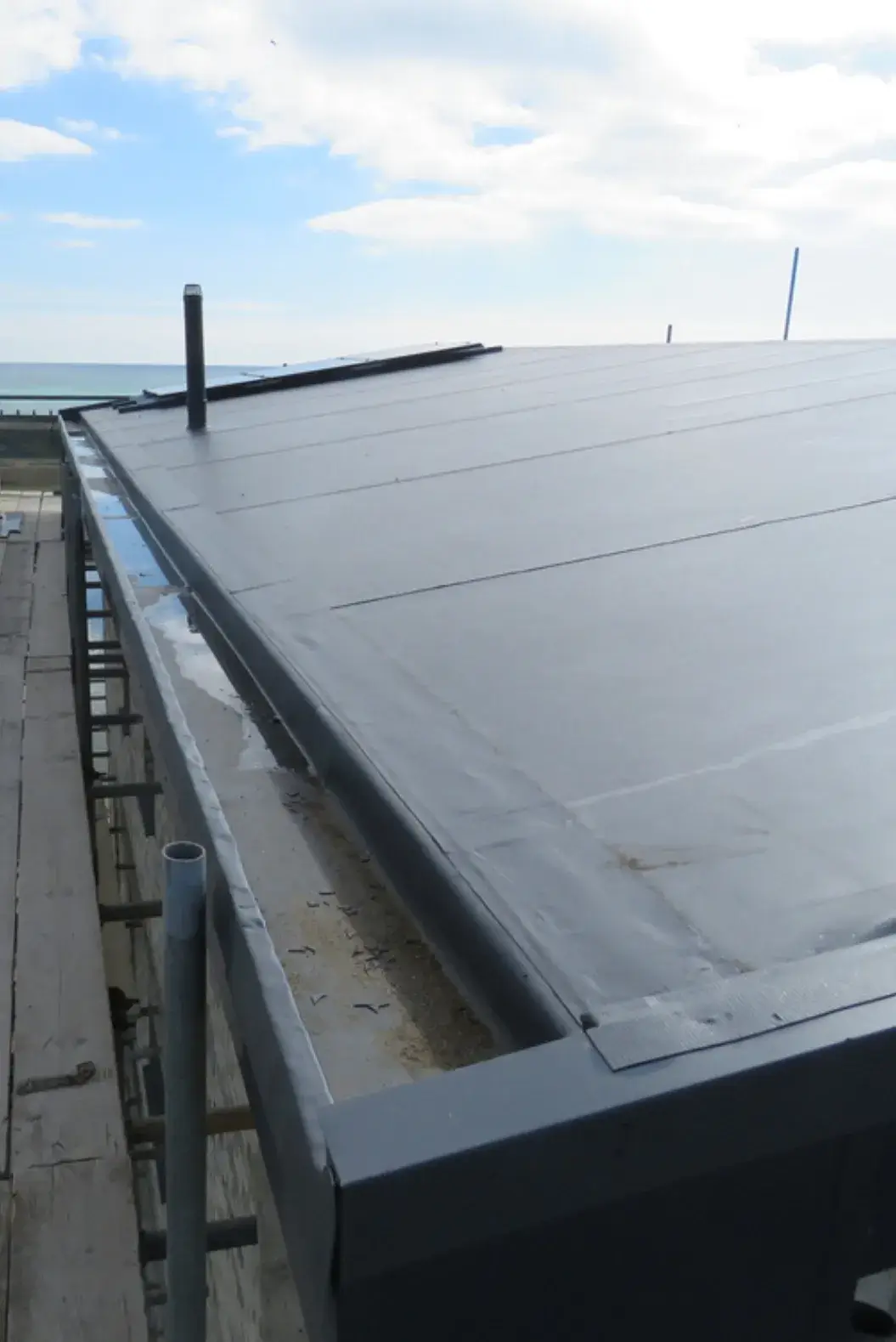 Close-up view of a flat roof with waterproof membrane installation.